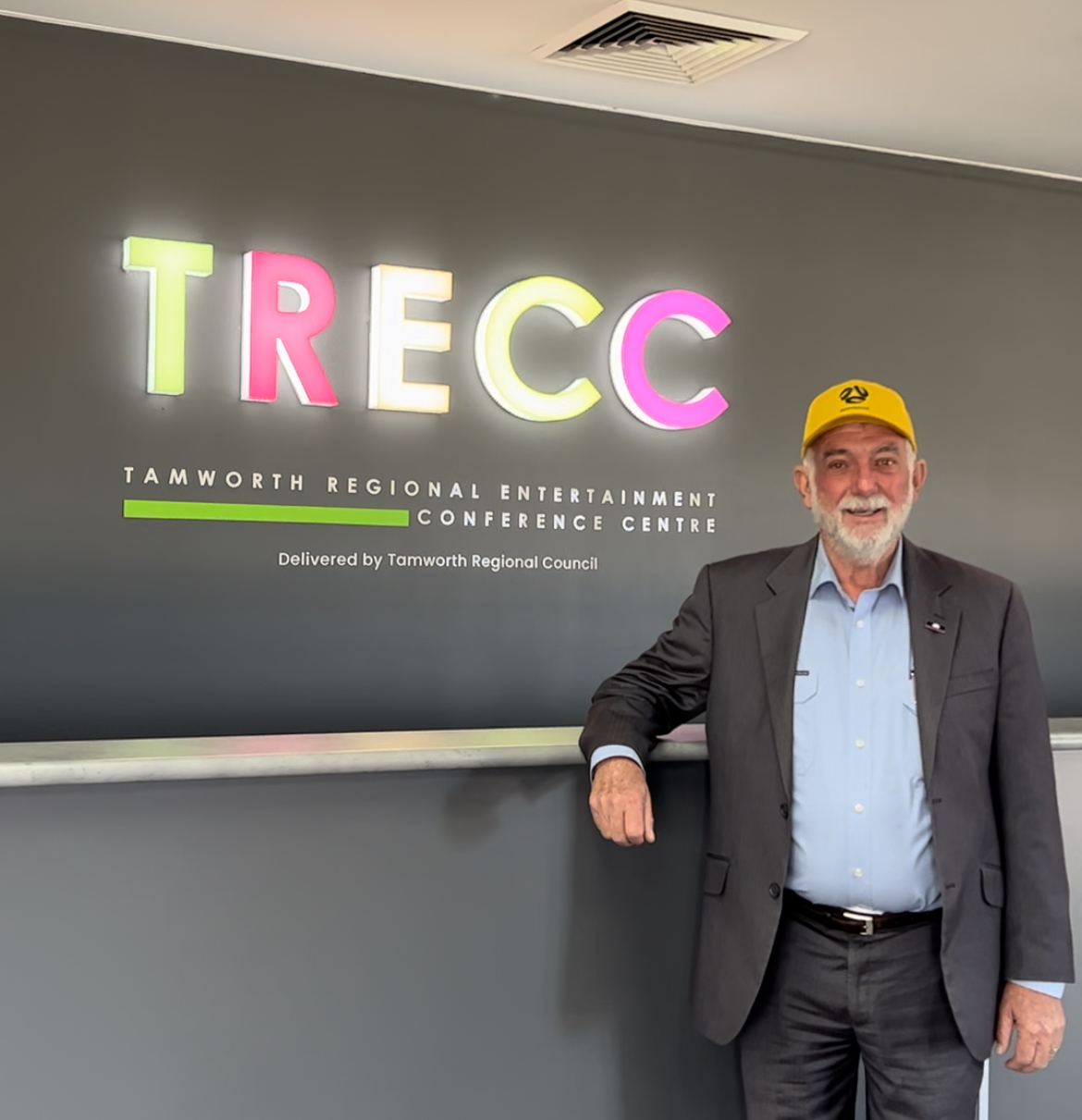 Mayor in front of TRECC signage for Matildas game